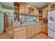 Well-equipped kitchen featuring light wood cabinets, granite counters, and built-in shelves at 18470 Canterbury Dr, Monument, CO 80132