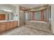 Luxurious main bathroom featuring a step-up tub, glass shower, and double vanity at 18470 Canterbury Dr, Monument, CO 80132