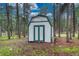 Charming backyard shed with green and white trim, nestled amongst mature trees at 18470 Canterbury Dr, Monument, CO 80132