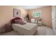 Bedroom featuring pink walls, an elegant bed, a patterned ottoman, and a bright window at 23 Hess Ave, Golden, CO 80401