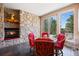 Cozy dining area with stone fireplace, glass table, and access to outdoor balcony with scenic views at 23 Hess Ave, Golden, CO 80401