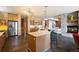 Beautiful kitchen boasts an island with barstool seating, stainless appliances, granite countertops, and flows into the living spaces at 23 Hess Ave, Golden, CO 80401