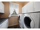 Functional laundry room with washer, dryer, white cabinets, and a window providing natural light at 23 Hess Ave, Golden, CO 80401