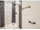 Modern shower with gray and white striped tiles and black hardware at 3200 S Federal Blvd # 5, Denver, CO 80236
