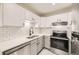 Well-lit kitchen with stainless steel appliances, modern backsplash, and sleek countertops at 3200 S Federal Blvd # 5, Denver, CO 80236