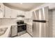 Modern kitchen with white cabinets, stainless steel appliances, and stylish backsplash at 3200 S Federal Blvd # 5, Denver, CO 80236