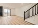 Open-concept living room with sleek floors, stairs and access to outdoor balcony at 3200 S Federal Blvd # 5, Denver, CO 80236