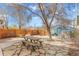 Fenced backyard with stone patio, mature shade tree, and outdoor seating area at 525 N Pearl St, Denver, CO 80203