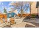 A spacious backyard featuring a mature tree, stone patio, and outdoor seating at 525 N Pearl St, Denver, CO 80203