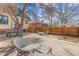 Backyard seating area with mature trees, stone patio, and wooden fence at 525 N Pearl St, Denver, CO 80203