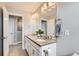 Well-lit bathroom with double sink vanity, a large mirror, and neutral gray walls at 2653 W 69Th Dr, Denver, CO 80221