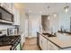 Well-equipped kitchen with stainless steel appliances, white cabinets, and a center island at 2653 W 69Th Dr, Denver, CO 80221