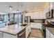 Open concept kitchen featuring a large island with seating, modern appliances, and wood flooring at 2653 W 69Th Dr, Denver, CO 80221