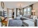 Cozy living room with a comfortable gray sectional sofa, stylish lighting, and natural light at 2653 W 69Th Dr, Denver, CO 80221