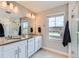 Main bathroom featuring double sinks, ample counter space, and a glass shower enclosure at 2653 W 69Th Dr, Denver, CO 80221