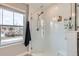 Shower with clear glass door, white subway tile, and bright natural light from the window at 2653 W 69Th Dr, Denver, CO 80221