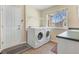 Functional laundry room with a washer, dryer, storage shelf, and a sink with counter space at 14461 Inca Ct, Westminster, CO 80023