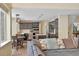 Open-concept living room flows into kitchen with dark cabinets, stainless appliances, and a dining area at 14461 Inca Ct, Westminster, CO 80023