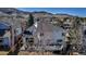 Aerial view of a backyard with a deck, wood pergola, and mature trees with mountain views at 69 Dawn Heath Cir, Littleton, CO 80127