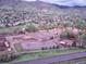 Aerial view of an equestrian center with riding areas and stables against a mountain backdrop at 69 Dawn Heath Cir, Littleton, CO 80127