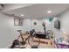 Basement gym area featuring exercise equipment and a mounted television for workouts at 69 Dawn Heath Cir, Littleton, CO 80127