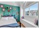 Bright bedroom with a large window, mountain views, and a decorative teal accent wall at 69 Dawn Heath Cir, Littleton, CO 80127