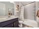 Stylish bathroom with a modern vanity, tiled shower-tub, and decorative floating shelves at 18187 E 99Th Ave, Commerce City, CO 80022