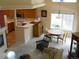 Open-concept living room with kitchen view, fireplace, and dining area featuring carpeted floors at 19692 E Mann Creek Dr # D, Parker, CO 80134