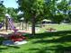 Community playground with a slide, picnic tables, and lush green grass at 19692 E Mann Creek Dr # D, Parker, CO 80134