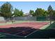 Outdoor tennis court surrounded by lush green trees on a clear sunny day at 19692 E Mann Creek Dr # D, Parker, CO 80134