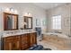 Bathroom with double vanity, soaking tub and tile surround at 1160 Monaco Pkwy, Denver, CO 80220