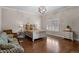 Comfortable bedroom featuring hardwood floors, a statement light fixture and neutral walls at 1160 Monaco Pkwy, Denver, CO 80220