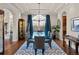 Formal dining room with an elegant chandelier, glass table and blue and white rug at 1160 Monaco Pkwy, Denver, CO 80220