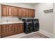 Convenient laundry room with custom cabinets, sink, and modern washer and dryer at 1160 Monaco Pkwy, Denver, CO 80220