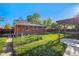 This brick home's backyard has green grass, a privacy fence, a pergola, and a pathway at 5661 E Amherst Ave, Denver, CO 80222