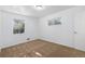 Bright bedroom with neutral carpet, white walls, and ample natural light from the windows at 5661 E Amherst Ave, Denver, CO 80222