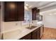 This kitchen features dark cabinetry, stainless steel appliances, a double sink, and attractive white counters at 5661 E Amherst Ave, Denver, CO 80222