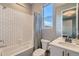 Bright bathroom with subway tile, shower-tub combo, stylish fixtures, and a window at 6058 Beeler Ct, Denver, CO 80238