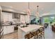 Elegant kitchen featuring stainless steel appliances, marbled backsplash, and an eat-in island at 6058 Beeler Ct, Denver, CO 80238