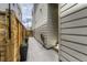 Side yard featuring a concrete path leading to a gated entrance, with a wall and greenery at 6058 Beeler Ct, Denver, CO 80238