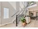 Bright entryway showcasing an open staircase with iron railings and light wood floors at 6058 Beeler Ct, Denver, CO 80238