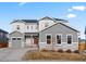 Beautiful two-story home featuring gray siding, stone accents, a red front door, and a well-maintained lawn at 3131 Keepsake Way, Castle Rock, CO 80109