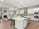 Modern kitchen with stainless appliances, kitchen island, tile backsplash, and open concept floorplan at 3131 Keepsake Way, Castle Rock, CO 80109