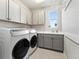 Well-organized laundry room with modern washer and dryer, storage cabinets, and sink area at 3131 Keepsake Way, Castle Rock, CO 80109
