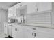 Modern kitchen featuring sleek countertops, a stainless steel sink, and white subway tile backsplash at 2544 S Raleigh St, Denver, CO 80219