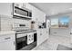 Modern kitchen with stainless steel appliances, tile backsplash, and white cabinets at 2544 S Raleigh St, Denver, CO 80219