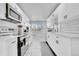 Well-equipped kitchen with stainless steel appliances, white cabinets, and modern tile flooring at 2544 S Raleigh St, Denver, CO 80219
