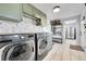 Well-lit laundry room with modern appliances, custom cabinetry, and practical storage solutions at 2544 S Raleigh St, Denver, CO 80219