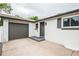A well-lit doorway and garage entrance with a neat painted exterior, complemented by dark shutters and matching trim at 320 S Jersey St, Denver, CO 80224
