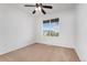 Bright bedroom with neutral carpet, ceiling fan, and a window with a view at 5255 Memphis St # 219, Denver, CO 80239